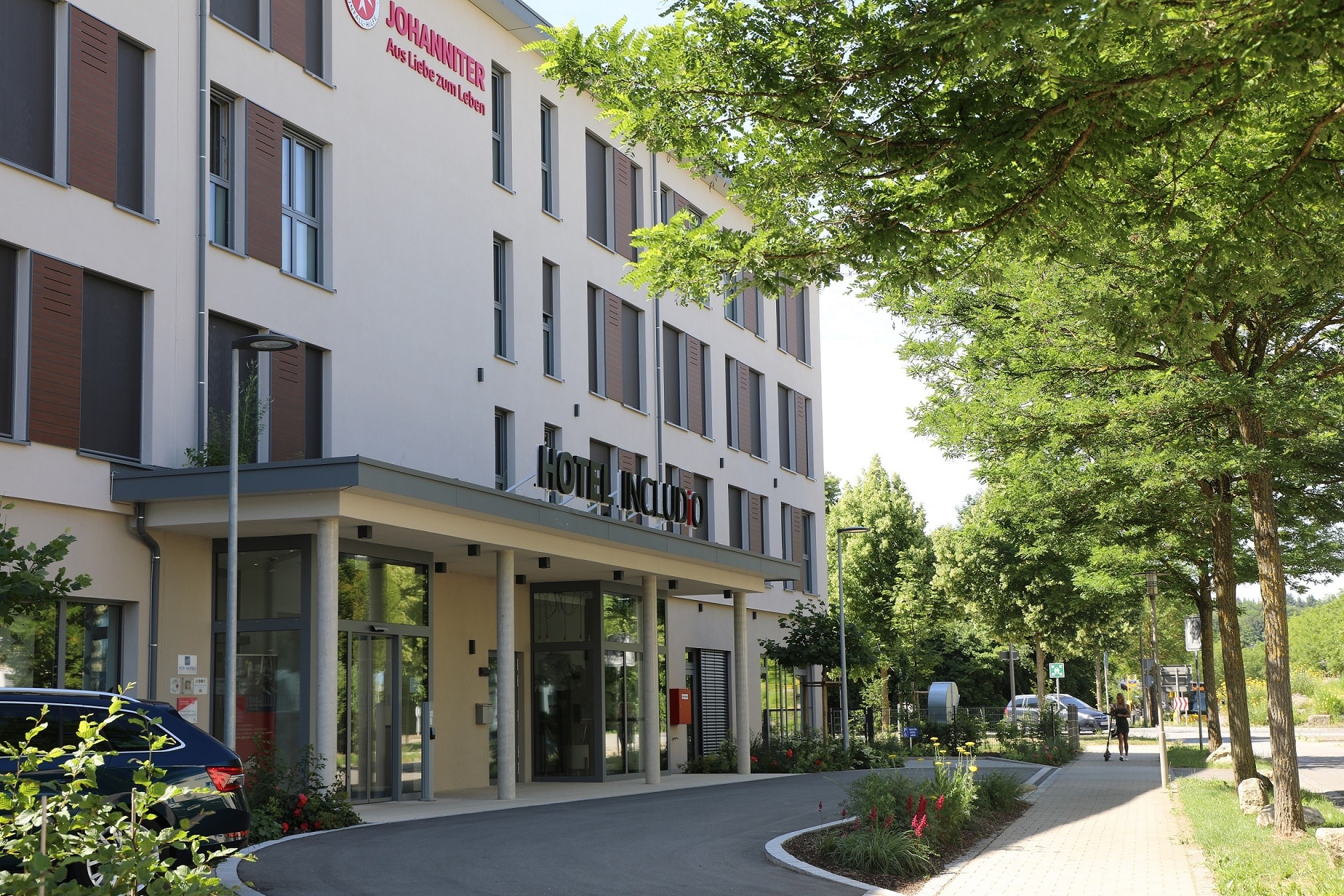 Front und Eingang mit Bäumen des ersten Inklusionshotels in Regensburg INCLUDiO komfortabel und barrierefrei