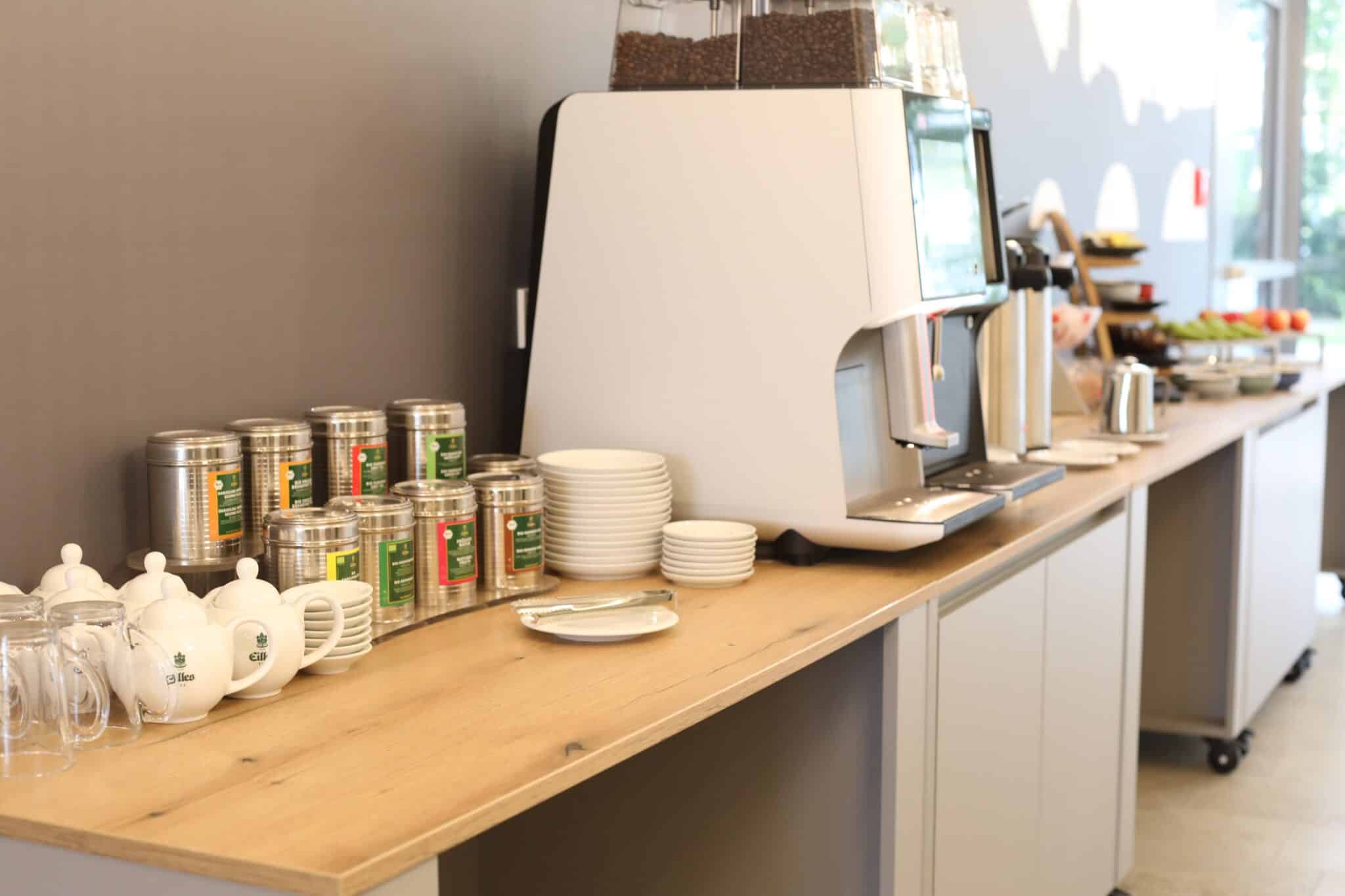 Coffee machine and dishes on a wooden shelf in a modern interior.
