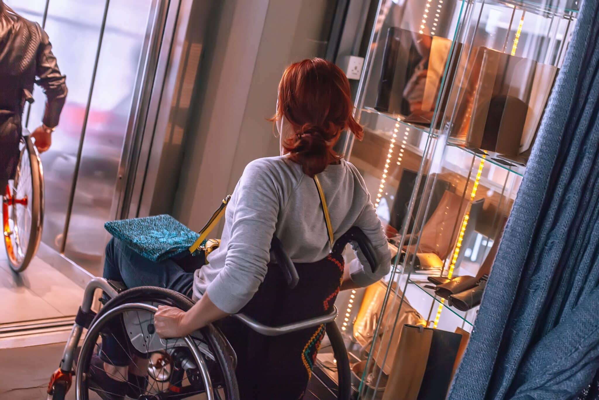 Eine Frau im Rollstuhl betritt den Aufzug